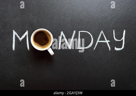 Iscrizione del lunedì e tazza di caffè sulla lavagna. Vista dall'alto. Concept Lucky lunedi con caffè. Foto Stock