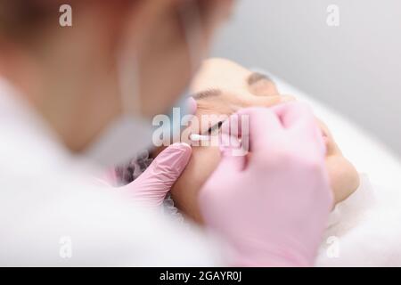 L'artista del tatuaggio prepara le palpebre per il closeup della procedura Foto Stock