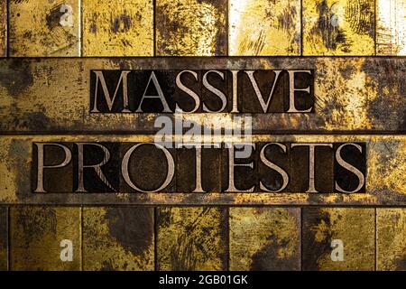 Messaggio di testo di massicce proteste su rame testurizzato grunge e sfondo oro vintage Foto Stock