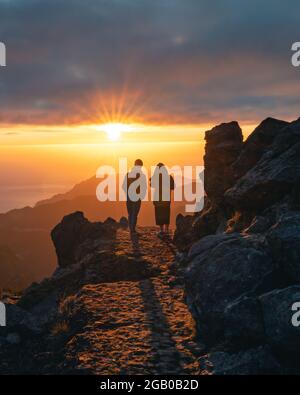 Felice giovane coppia che guarda l'alba dal picco di Pico do Arieiro a Madeira. Silhouette di coppia sulle montagne Foto Stock
