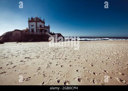 Vista della Cappella Senhor da Pedra su Praia de Miramar, Portogallo. Foto Stock