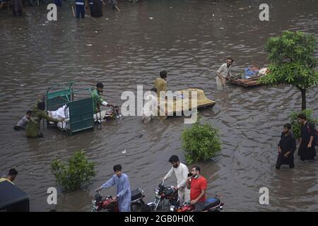 Lahore, Pakistan. 31 luglio 2021. I pendolari pakistani si muovono attraverso una strada allagata dopo un pesante incantesimo monsone nella capitale provinciale Lahore. (Foto di Rana Sajid Hussain/Pacific Press) Credit: Pacific Press Media Production Corp./Alamy Live News Foto Stock