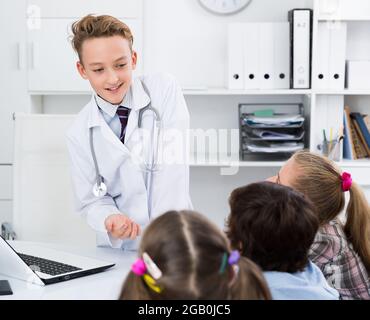 Ragazzo medico con stetoscopio che parla Foto Stock