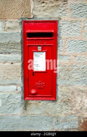 Una scatola postale, prodotta dalla Carron di Falkirk, con un avviso indicante i tempi di raccolta, inserita in un muro di Prestwick, nell'Ayrshire meridionale, Scozia Foto Stock