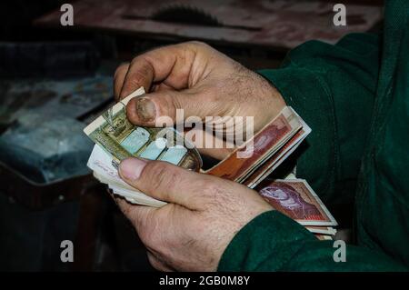 Uomo che conta denaro, concetto di economia, allocazione di denaro. I lavoratori contano a mano i soldi della carta. Foto Stock