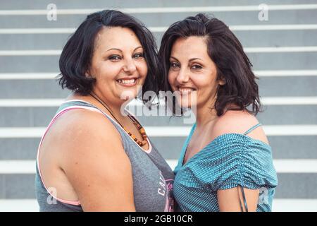 Ritratto di due sorelle gemelle brunette adulte. Stili diversi Foto Stock