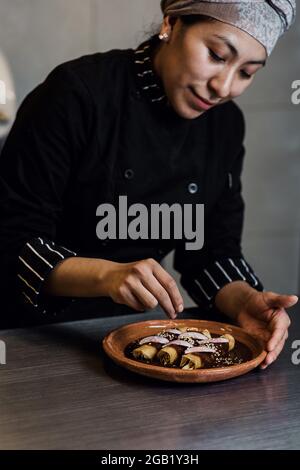 donna messicana che cucina poblano enchiladas cibo tradizionale in un ristorante in Messico Foto Stock