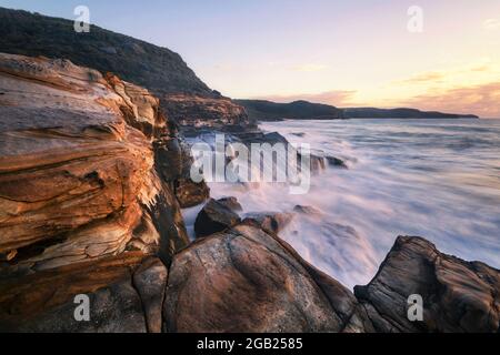 acqua che scende lungo le rocce lungo la costa Foto Stock