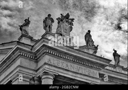 Dettagli dell'entablatura con statue di santi religiosi sui colonnati della Basilica di San Pietro in Piazza San Pietro a Città del Vaticano, Roma, Italia Foto Stock