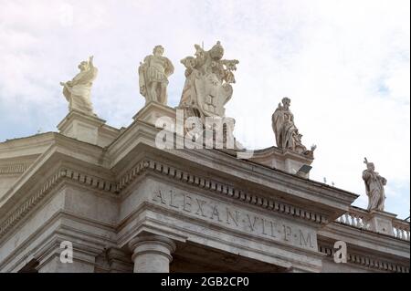 Dettagli dell'entablatura con statue di santi religiosi sui colonnati della Basilica di San Pietro in Piazza San Pietro a Città del Vaticano, Roma, Italia Foto Stock