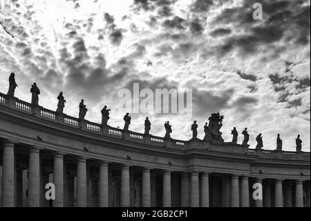 Dettagli dell'entablatura con statue di santi religiosi sui colonnati della Basilica di San Pietro in Piazza San Pietro a Città del Vaticano, Roma, Italia Foto Stock