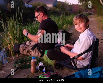 Un ragazzo e suo papà pescarsi sul canale Sheffield e Tinsley, nello Yorkshire meridionale Foto Stock