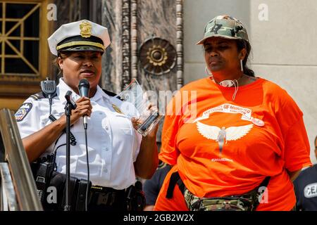 Il tenente di polizia Melissa McFadden riceve un trofeo ringraziandola per il suo sostegno alle madri dei bambini assassinati di Colombo (MOMCC) dal fondatore del MOMCC, Malissa Thomas St. Clair, durante un raduno contro la violenza al Municipio di Columbus. In reazione alla crescente violenza dal 2020 Malissa Thomas-St Clair, madre di un figlio assassinato, Anthony Thomas-St Clair, fondò Mothers of assassined Columbus Children (MOMCC), un gruppo anti-violenza che cerca di porre fine alla criminalità violenta a Columbus, Ohio. MOMCC ha guidato lo sforzo per una marcia e un rally anti-violenza dell'Ohio centrale al municipio con molte altre madri Foto Stock