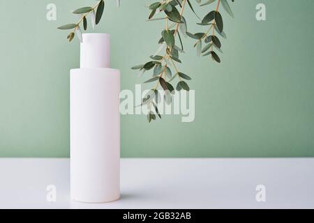 Prodotto cosmetico di bellezza in bottiglia bianca su sfondo verde. Cosmetici naturali biologici Foto Stock