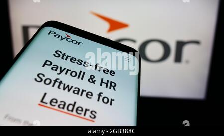 Smartphone con sito web della società di software HR americana Paycor HCM Inc. Sullo schermo davanti al logo aziendale. Mettere a fuoco in alto a sinistra del display del telefono. Foto Stock