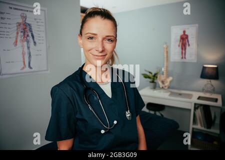 Donna caucasica in piedi in clinica indossando scrub Foto Stock