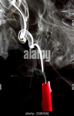 Una spirale bianca di fumo da una candela estinta Foto Stock