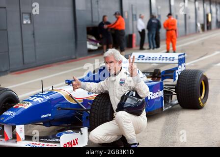 Damon Hill in posa accanto al suo Campionato del mondo vincendo la Williams FW18 Formula One Car, dopo aver eseguito diversi giri dimostrativi ad alta velocità del circuito, al Silverstone Classic 2021 Foto Stock