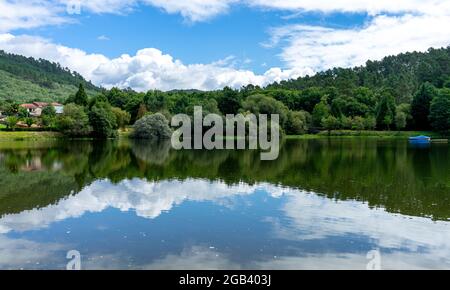 lago in cui il cielo e gli alberi che lo circondano sono riflessi Foto Stock