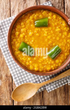 Il kik alicha è un tradizionale piatto vegetariano etiope a base di piselli spezzati gialli, kibbeh curcuma e nitro. Primo piano nella ciotola sul tavolo. Vertic Foto Stock