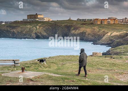 Una donna che cammina il suo cane su Towan Head si affaccia sulla zona conosciuta localmente come il Gazzle sulla costa di Newquay in Cornovaglia. Foto Stock