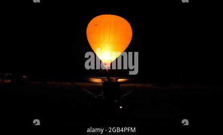 Thiene, Italia, 8 LUGLIO 2021, pallone ad aria calda illuminato dalla fiamma a gas nella notte. Ballons Libert L 3400 Foto Stock
