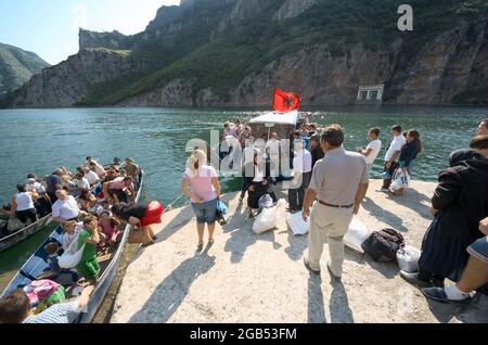 Gente del posto e turisti nel nord dell'Albania lago Koman attracco del traghetto per il prelievo dei passeggeri da Fierze a Koman e ritorno - agosto Foto Stock
