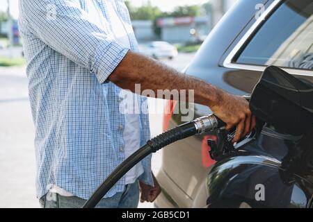 Uomo che riforna benzina in automobile alla stazione di benzina Foto Stock