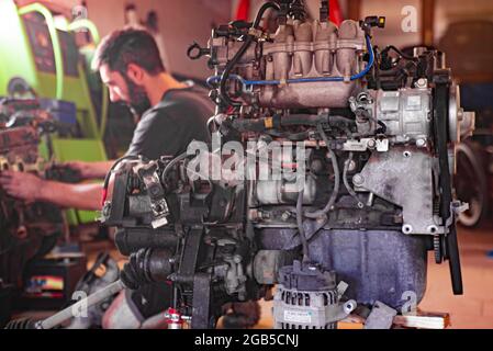 Dettaglio del meccanico revisiona il motore di un'auto in un'officina Foto Stock