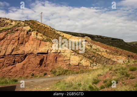 Chiara e ben definita dyke di dolerite, tagliando attraverso arenaria gialla Clarens e fango di Elliot rossastro, a Rooidraai nella Golden Gate Highlands Nati Foto Stock