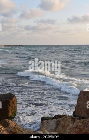 Onde che infrangono vicino Mossy Rocks a Mediterranean Shoreline Foto Stock