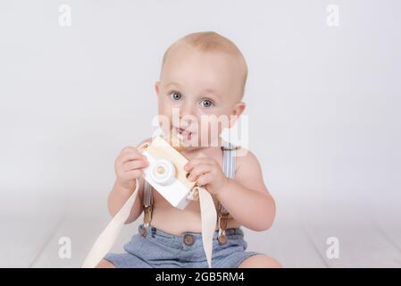 bambino con vecchia macchina fotografica su sfondo bianco Foto Stock