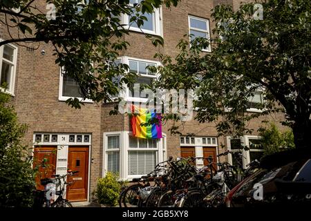 AMSTERDAM, PAESI BASSI - 26 giu 2021: Bandiera dell'arcobaleno LGBTQ appesa su una facciata esterna di una casa ad Amsterdam, Paesi Bassi Foto Stock