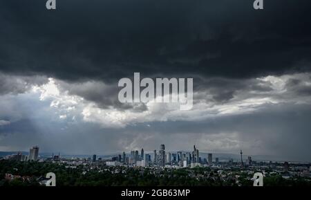 02 agosto 2021, Hessen, Francoforte sul meno: Le nuvole scure della pioggia passano sopra l'area della città di Francoforte con i suoi impressionanti grattacieli nel pomeriggio. Foto: Arne Dedert/dpa Foto Stock