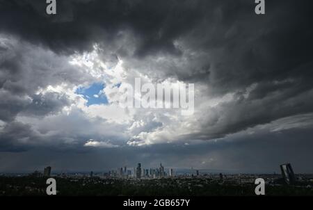 02 agosto 2021, Hessen, Francoforte sul meno: Le nuvole scure della pioggia passano sopra l'area della città di Francoforte con i suoi impressionanti grattacieli nel pomeriggio. Foto: Arne Dedert/dpa Foto Stock