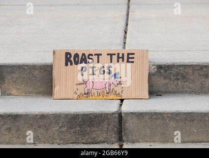 segno che chiede di arrostire i maiali durante una protesta Foto Stock