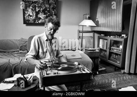 Uomo che suona dischi in vinile su un vecchio giradischi in una scena retrò classica Gran Bretagna, Regno Unito. Lettore di registrazioni musicali che registra hi-fi. Foto DAVID BAGNALL Foto Stock