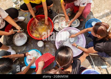 Le donne lavare le loro stoviglie, bacchette e posate all'interno delle antiche mura della città di Zhaoqing in Cina. Lavaggio comunale up è un passatempo molto diffuso Foto Stock