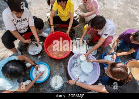 Le donne lavare le loro stoviglie, bacchette e posate all'interno delle antiche mura della città di Zhaoqing in Cina. Lavaggio comunale up è un passatempo molto diffuso Foto Stock