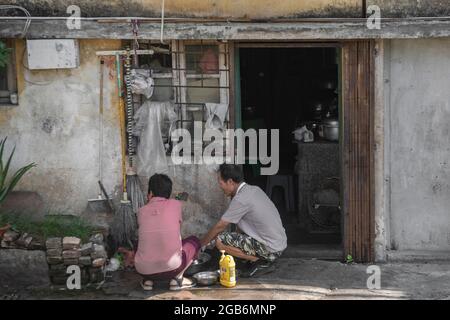 Una coppia lavi le loro stoviglie, i chopsticks e le posate all'interno dell'antica città murata di Zhaoqing in Cina. Il lavaggio comunale è un passatempo popolare Foto Stock