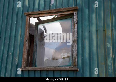 finestrino rotto su un vecchio rimorchio da costruzione, anche il tetto del rimorchio è rotto Foto Stock