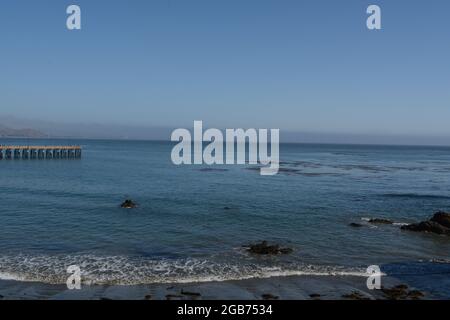 Cayucos state Beach con il molo di Cayucos sulla baia di estero. Nella contea di San Luis Obispo, California Foto Stock