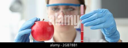 Il medico sta tenendo la mela rossa e striscia con le misure Foto Stock