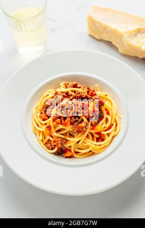 Spaghetti alla Bolognese piatto di pasta italiana con parmigiano stagionato e vino bianco - FOODPIX BIANCO Foto Stock