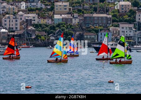 Barche colorate raffigurate sul fiume Fowey / estuario con Polruan sullo sfondo - Fowey, Cornovaglia, Regno Unito. Foto Stock