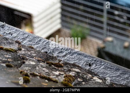 Grondaia ostruita piena di acqua che trabocca in tempo piovoso. Foto Stock