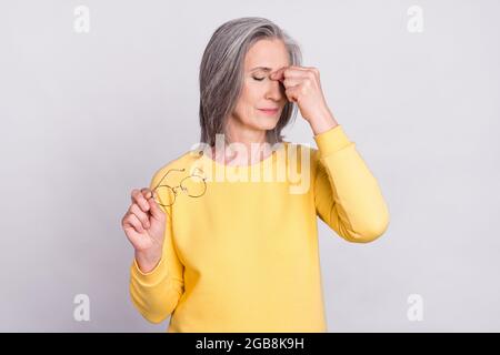 Foto di infelice triste stressato donna matura che soffre mal di testa overworked isolato su sfondo grigio Foto Stock