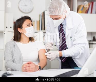 Medico che dà Covid-19 o vaccino antinfluenzale anti vaccinato al paziente Foto Stock