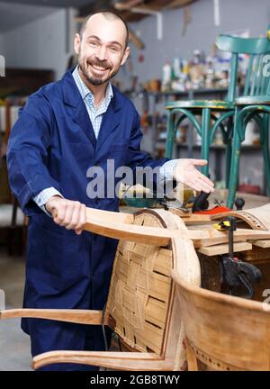 Artigiano in laboratorio di restauro di mobili Foto Stock