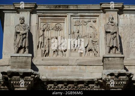 Statue daciane e rilievi Aureliani all'arco trionfale Arco di Costantino, dietro l'Anfiteatro Colosseo, Roma Foto Stock